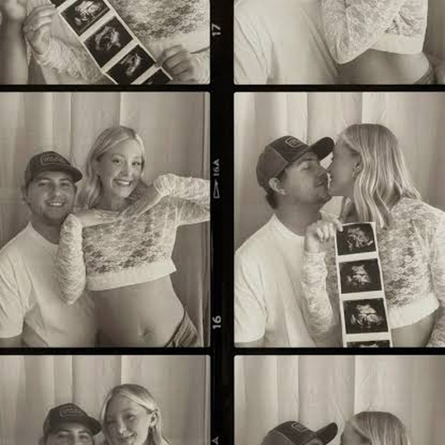 A couple in a photo booth holding up an ultrasound strip