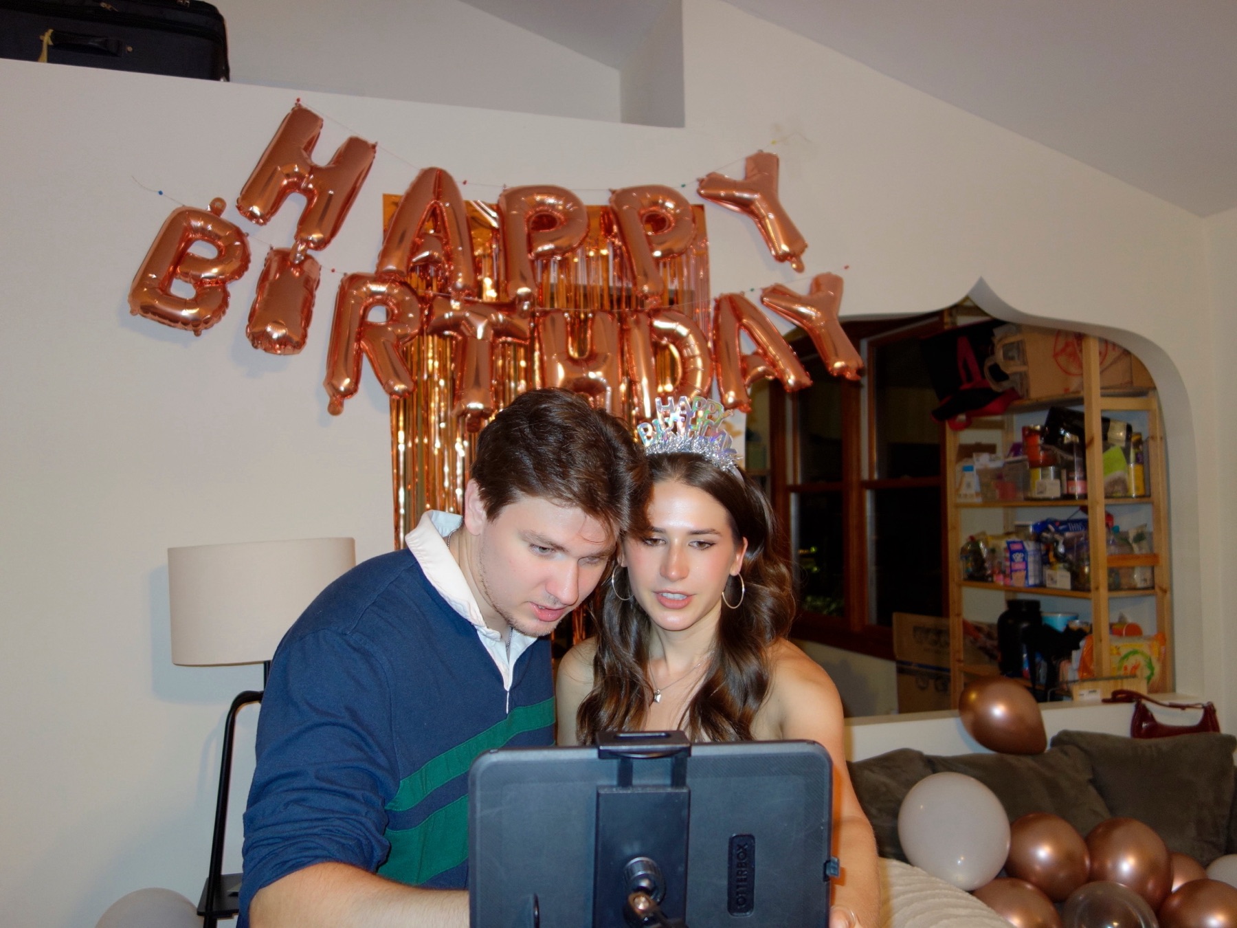 A guest lining up a shot on Confetti at a birthday party, balloons and a foil backdrop behind her